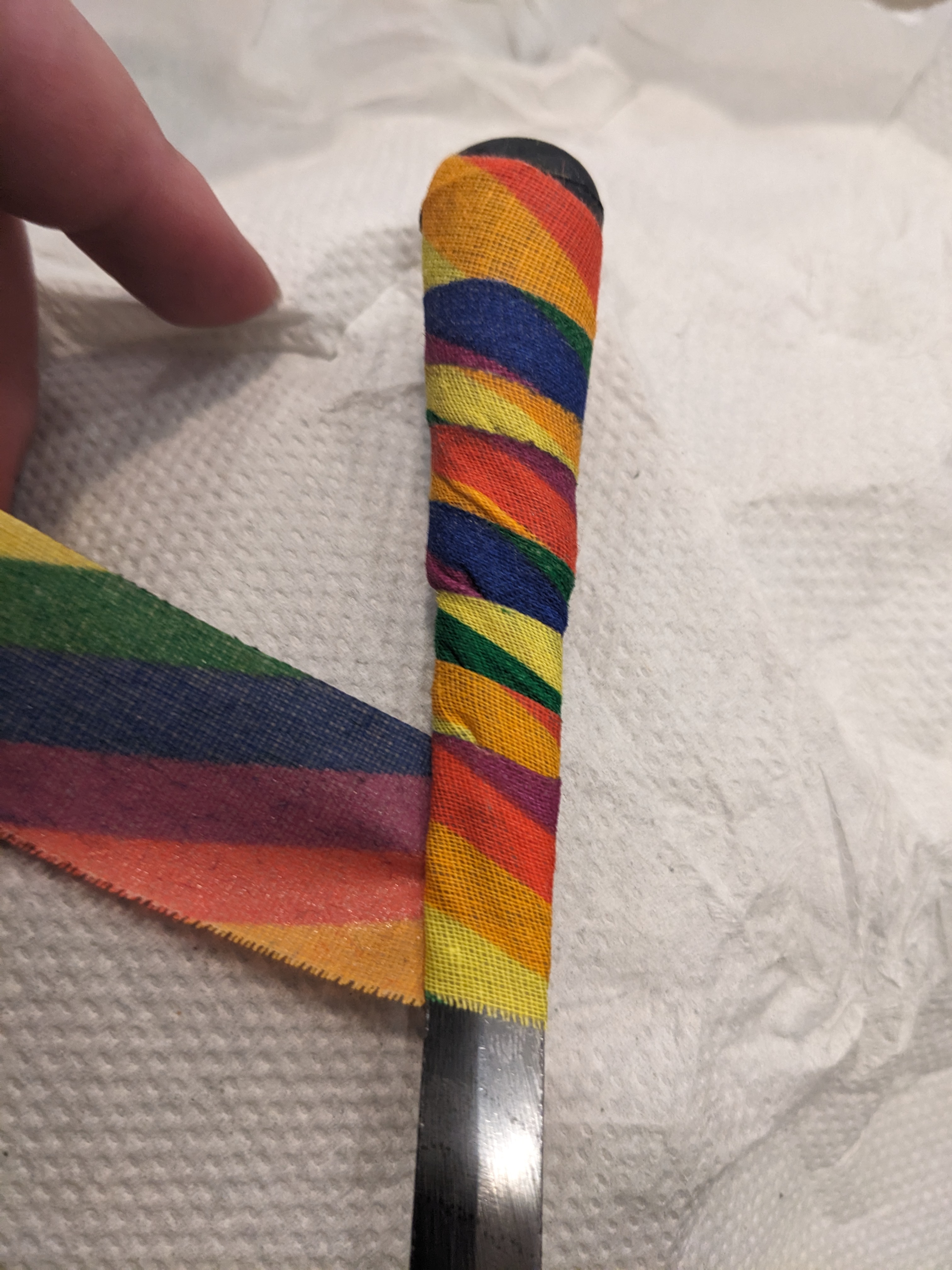 Dagger tip with black rubber tip, wrapped in rainbow tape, first wrap