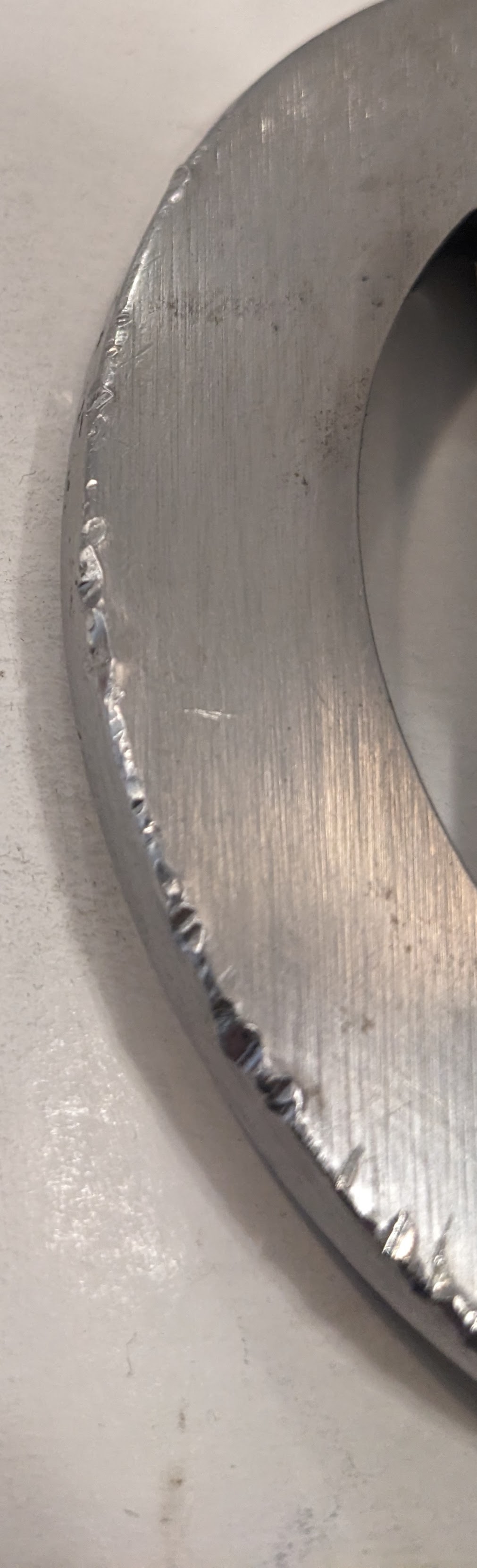 Rounded edge of katana tsuba with lots of nicks in it