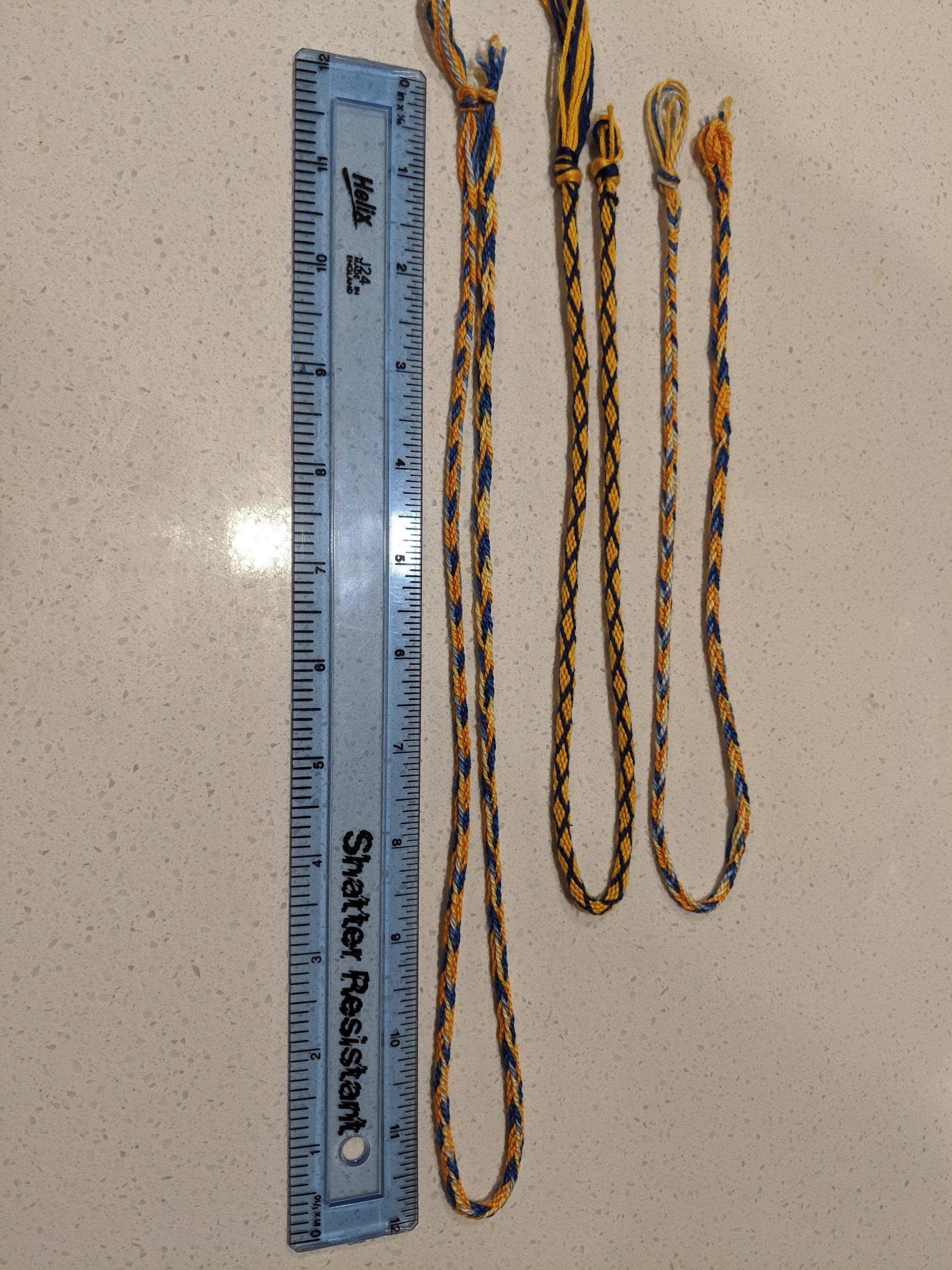 Comparison of two fingerloop braids, one kumihimo braid, ruler.