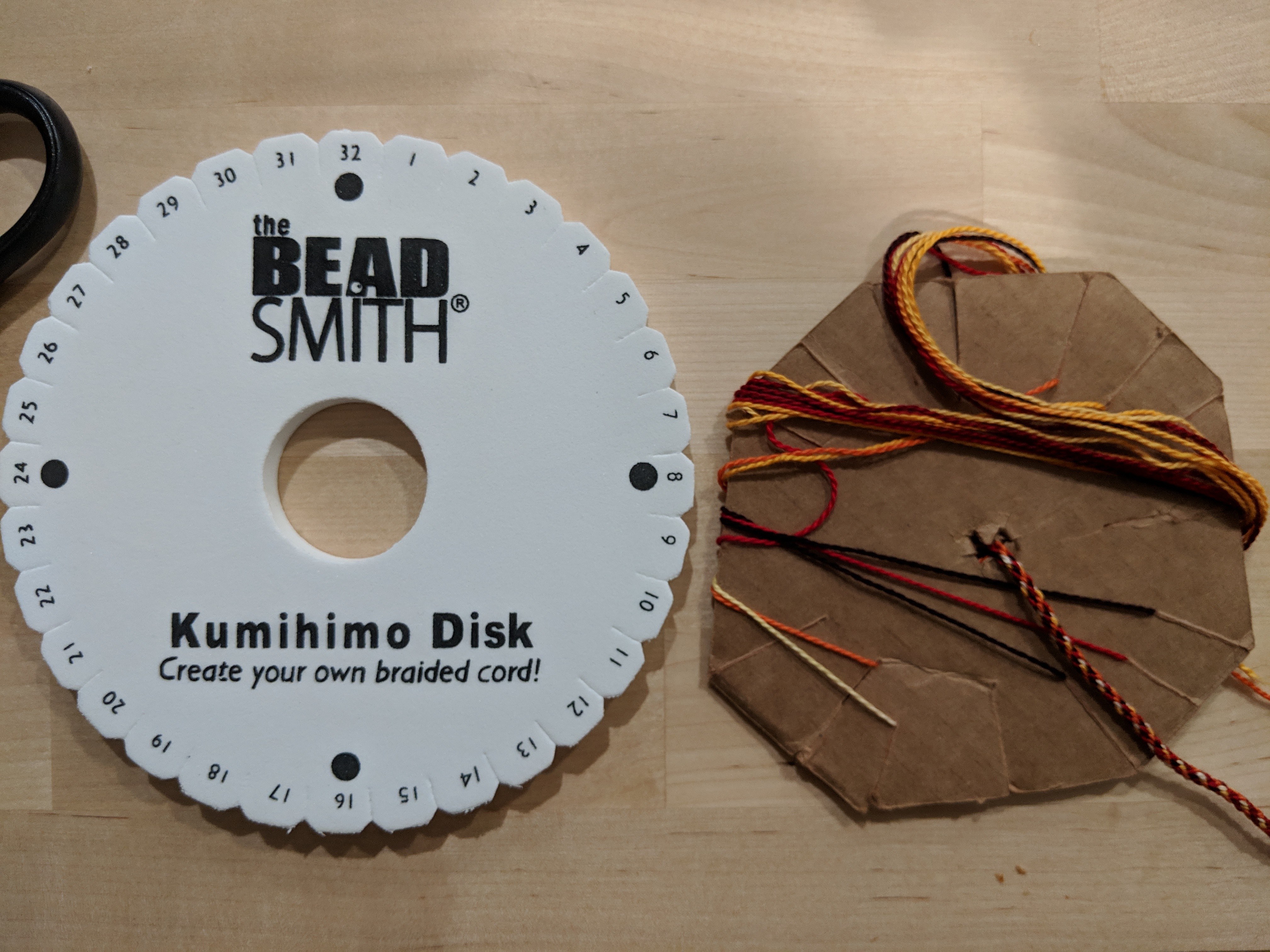 Two kumihimo disks, foam on left, cardboard on right. Foam is an inch larger in diameter.